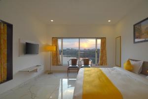 乌代浦Atrangi Hotel & lakeview cafe at PICHOLA LAKE by JD的一间卧室设有一张床和一个美景窗户。