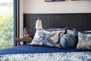 海姆斯海滩Hyams Beach House B - Brand new lux beach oasis的一张带蓝色和白色枕头的床和一盏灯