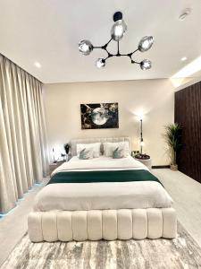 麦纳麦Harbour View Condo - Seaview اطلالة بحرية的卧室配有一张带吊灯的大型白色床。