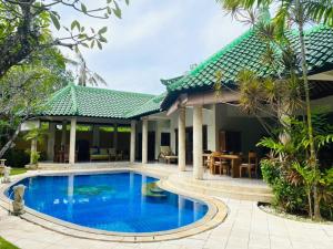 沙努尔巴厘岛翡翠别墅酒店的别墅前设有游泳池
