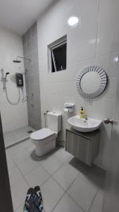 帕帕尔RHR Deluxe GuestHouse Kinarut Papar Sabah - Mountain View的一间带卫生间、水槽和镜子的浴室