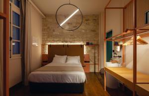 利马索尔Heart Hotel的一间带一张床铺的卧室,位于带书桌的房间