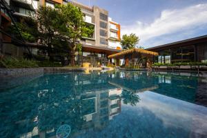 Ban KohongRichmann Resort Hotel Hatyai的大楼前的游泳池