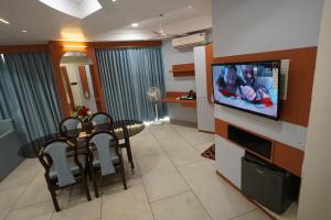 甘德希罕HOTEL GOKUL的客厅配有餐桌和平面电视。