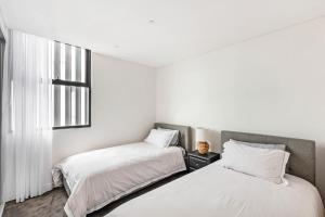 Barrack PointShellharbour Lakeview Apartment的配有2张床的白色墙壁和窗户。