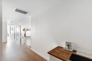 Barrack PointShellharbour Lakeview Apartment的走廊设有白色的墙壁和木桌