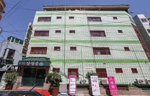 釜山Prince Motel的前面有标志的高大的白色建筑