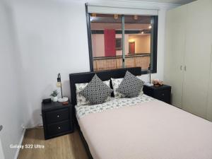 悉尼Beautiful apartment in Pyrmont的卧室配有带枕头的床铺和窗户。