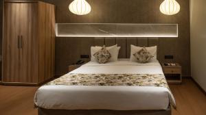 西里古里灰姑娘酒店的卧室配有一张带两个枕头的大白色床