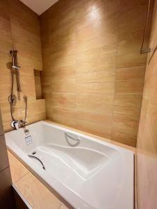 乌隆他尼9D City & 9D Express Hotel的木墙客房内的大型白色浴缸