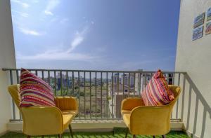 瓦斯科达伽马Coral BnB Premium 2 BHK Apartment - 5 km from Dabolim Airport的两把椅子坐在一个美景阳台