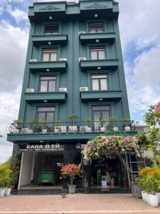 Bắc GiangSky Hotel的前面有鲜花的绿色建筑
