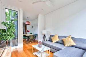 悉尼Astounding 3 Bedroom House Surry Hills 2 E-Bikes Included的客厅配有蓝色的沙发和桌子