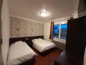 亚眠空间酒店的一间卧室设有两张床和窗户。