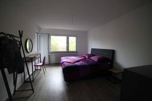 诺伊斯Designer-Apartment near Düsseldorf+Cologne (Apt.3)的一间卧室配有一张床、一张书桌和一个窗户。