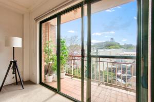 悉尼Cozy 2 Bedroom Apartment Surry Hills的客房设有带滑动玻璃门的阳台。