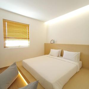 名古屋ManukabyHavis Boutique Hotel的卧室设有一张白色大床和一扇窗户。