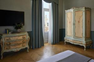 加尔多内-里维耶拉戴索诺别墅酒店的一间卧室设有梳妆台和大窗户
