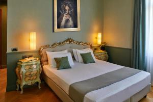 加尔多内-里维耶拉戴索诺别墅酒店的卧室,配有一张床和一张女人的肖像