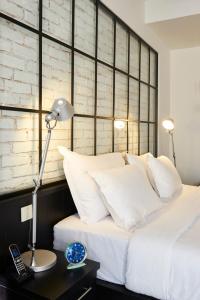 伊斯坦布尔Magnova Studios的一张带白色枕头的床和一张带台灯的桌子