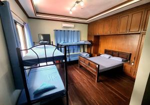TanauanLeynes Taal Lake Resort and Hostel的客房设有两张双层床和一张书桌。