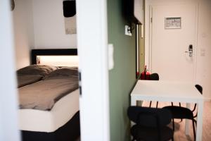 埃尔姆斯霍恩Homaris Apartments Elmshorn的卧室配有一张床和一张桌子及椅子