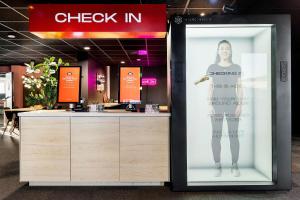 斯彻达尔Aiden by Best Western Trondheim Airport的女顾客站在展品上的商店标志