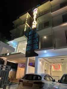 韦利格默Mzion Hotel Weligama的夜间停在大楼前的汽车