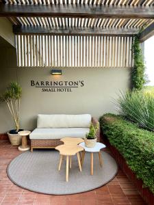 普利登堡湾Barrington's的地毯上设有带沙发和桌子的庭院