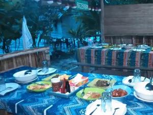 BesirBeser Bay Homestay的一张桌子,上面有盘子,放在蓝色的桌布上