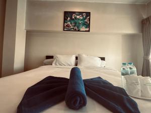 Ban Lam Rua Taekนวนคร ออมสินอพาร์ตเมนต์ ติดห้างบิกซี Navanakorn Aomsin hotel near shopping mall,snooker and club的床上铺着蓝色毛巾