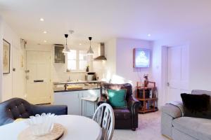汤布里奇Pass the Keys Cute flat in Tonbridge的厨房以及带桌椅的起居室。
