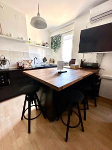 萨格勒布Apartment PM的厨房配有带酒吧凳的大木桌