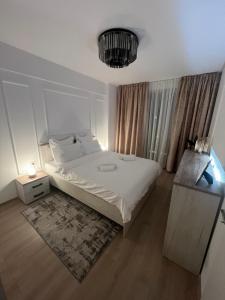 蒂米什瓦拉Modern Apartment in Timisoara的卧室配有白色的床和吊灯。