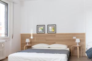 梅莱尼亚诺New Exclusive Melegnano Apartments- Near train station的一间卧室配有一张大床和两盏灯