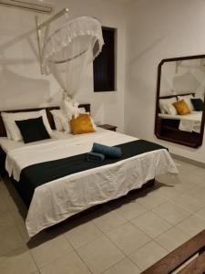 尼甘布玛丽亚别墅酒店的一间卧室配有一张大床和镜子