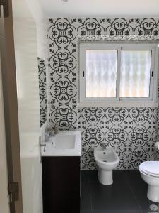 里斯本Casa da Branca Gonta Colaço的一间带水槽和卫生间的浴室以及窗户。