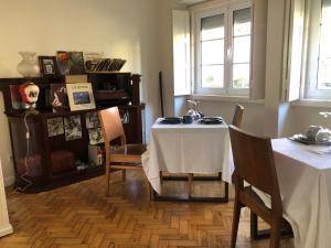 里斯本Casa da Branca Gonta Colaço的一间带桌子和两张桌子及椅子的用餐室