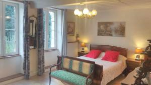 Bellignat阿啦格勒努耶杜汝拉住宿加早餐旅馆的一间卧室配有一张带红色枕头的床和一把椅子