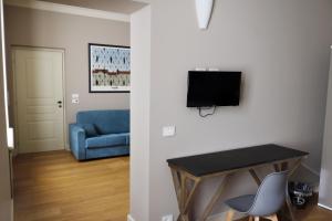 QuattordioAlbergo '900的客厅配有蓝色的沙发和墙上的电视