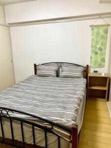 名古屋Maison Etoile Room 705 - Vacation STAY 14807的一间卧室配有带白色床单和枕头的床。