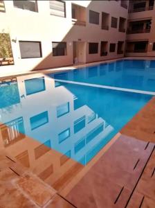 马拉喀什Beautiful apartment in gueliz with swimming pool的大楼中央的大型游泳池