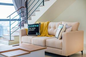 吉隆坡Arte Mont Kiara by Cobnb的客厅配有带枕头的沙发