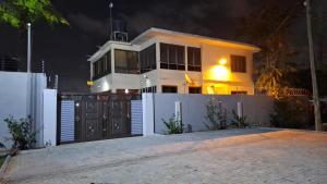 阿克拉A Cozy Luxury Hideout in North Ridge, Accra, 1BDRM - 2BDRM, 15 mins from Airport的白色的房子,有门和栅栏