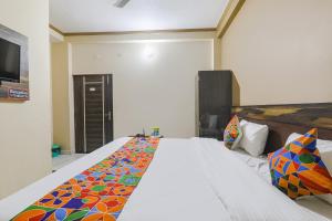 瓦拉纳西FabHotel SR的一间卧室配有一张带彩色毯子的床