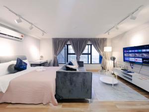 吉隆坡Arte Cheras Luxury Suites by THE STAY HUB的一间白色卧室,配有一张大床和一台电视