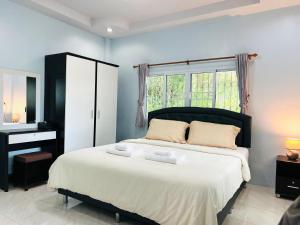 武里南Xaiyong Resort - ไทรโยงรีสอร์ท的一间卧室配有带梳妆台和窗户的床。
