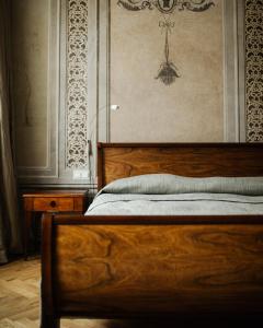 克拉科夫罗萨博得酒店的一间卧室设有木床和墙壁