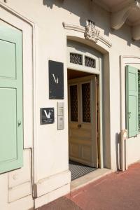 里摩日VILLA FLEURY - APPART'HÔTEL DE STANDING的白色建筑的前门,有绿色的门