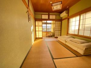 高山Guesthouse Takayama Hanzansha的带窗户的客房内设有两张床的房间